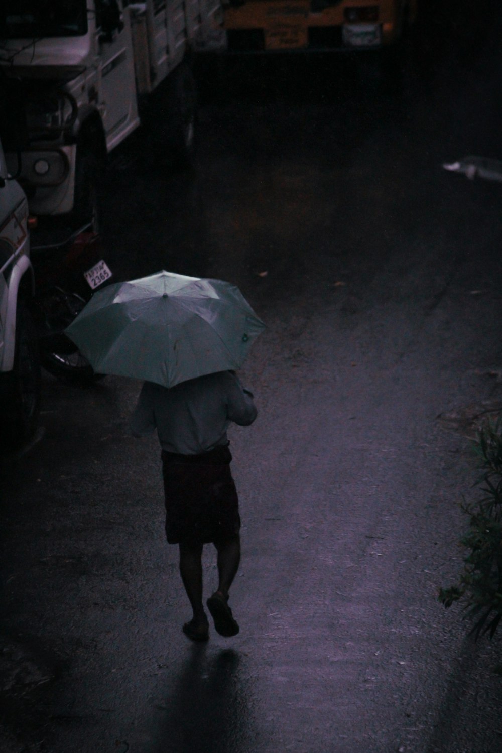 Eine Person, die eine Straße entlang geht und einen Regenschirm hält