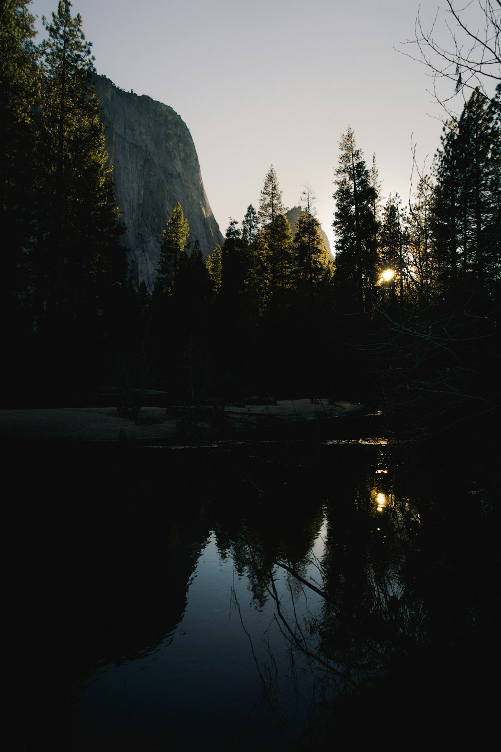 a lake surrounded by trees and a mountain in the background