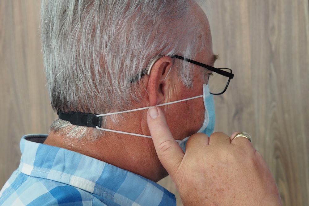 a man wearing a headset and a blue plaid shirt