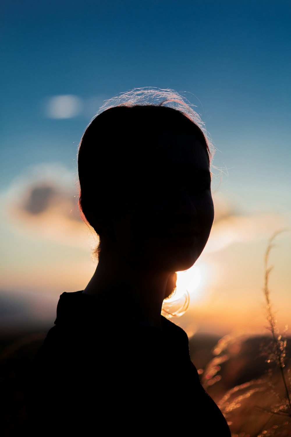 a silhouette of a person with the sun in the background