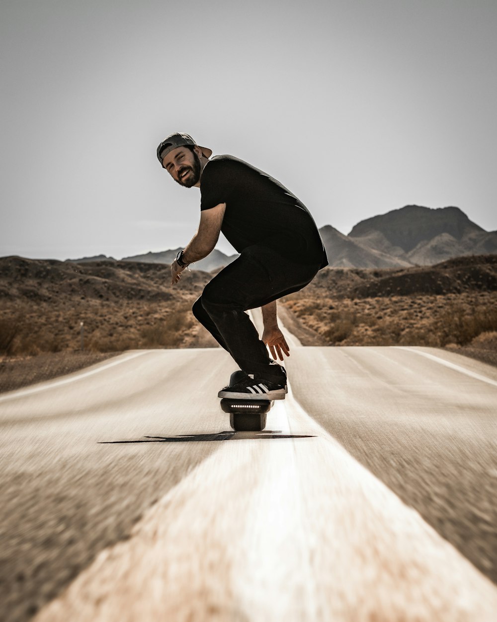 a man riding a skateboard down the middle of a road