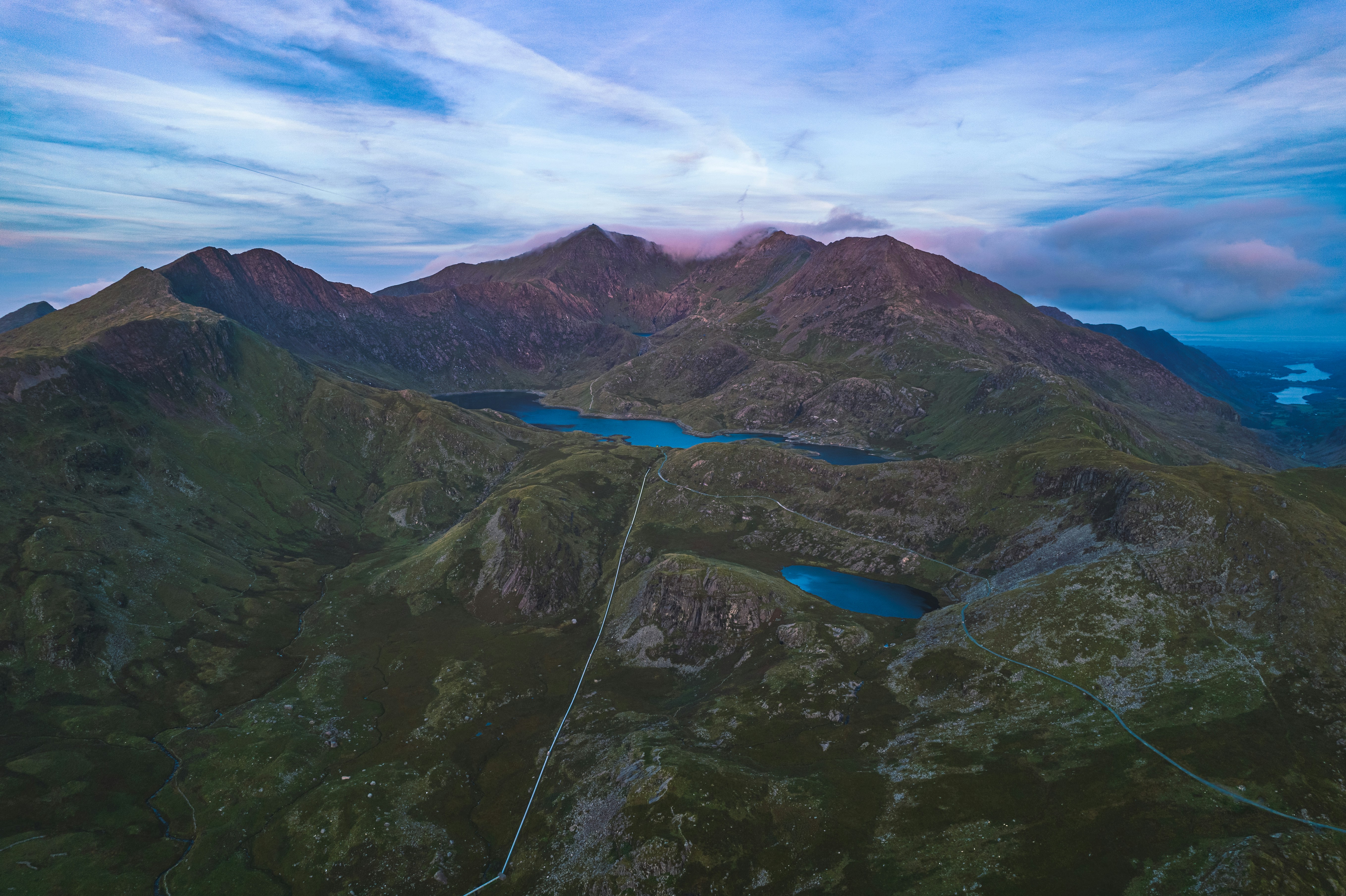 an aerial view of a mountain range with a lake in the foreground