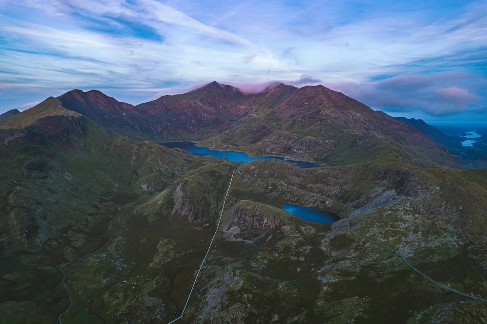 an aerial view of a mountain range with a lake in the foreground