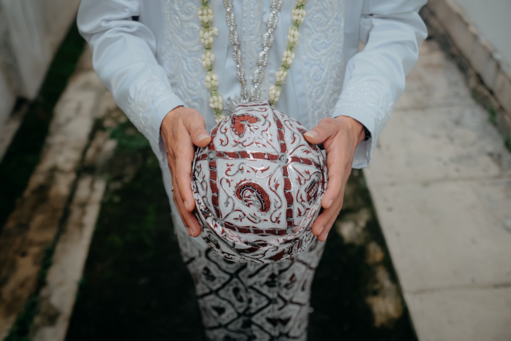 a person holding a decorative object in their hands