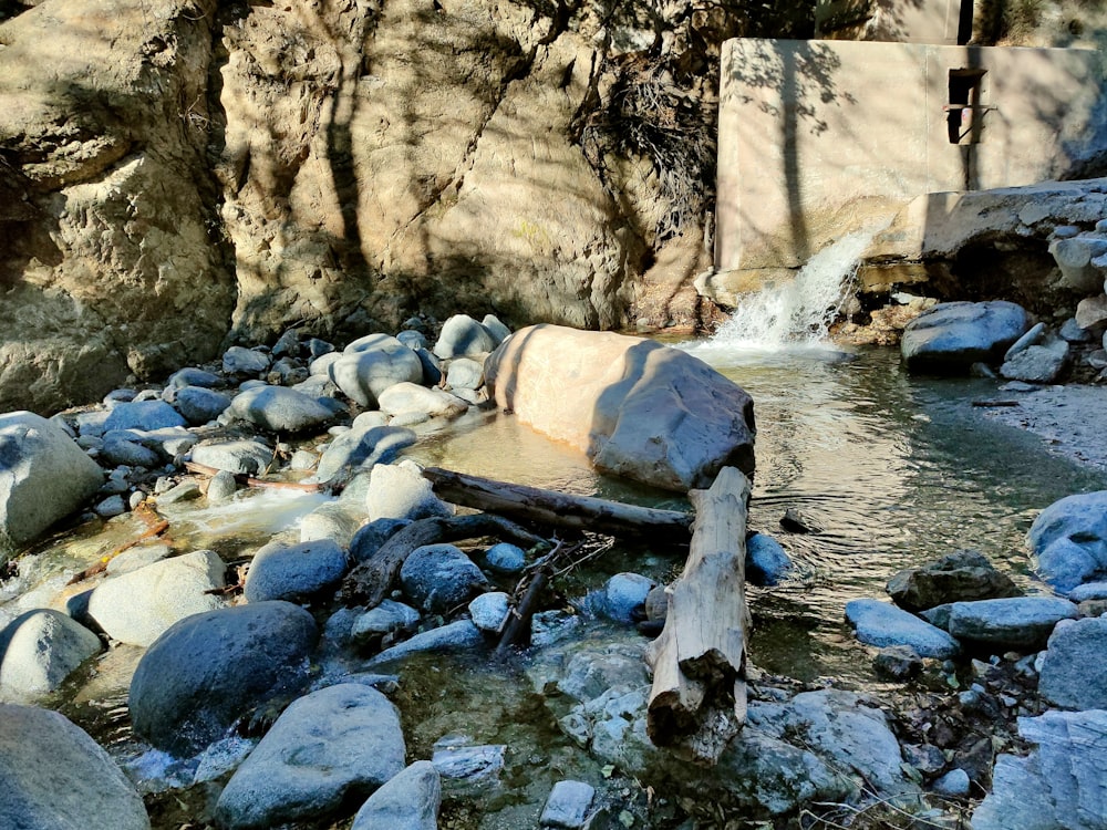 a stream of water running through a rocky hillside