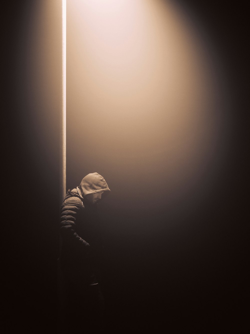 a person standing under a street light in the dark
