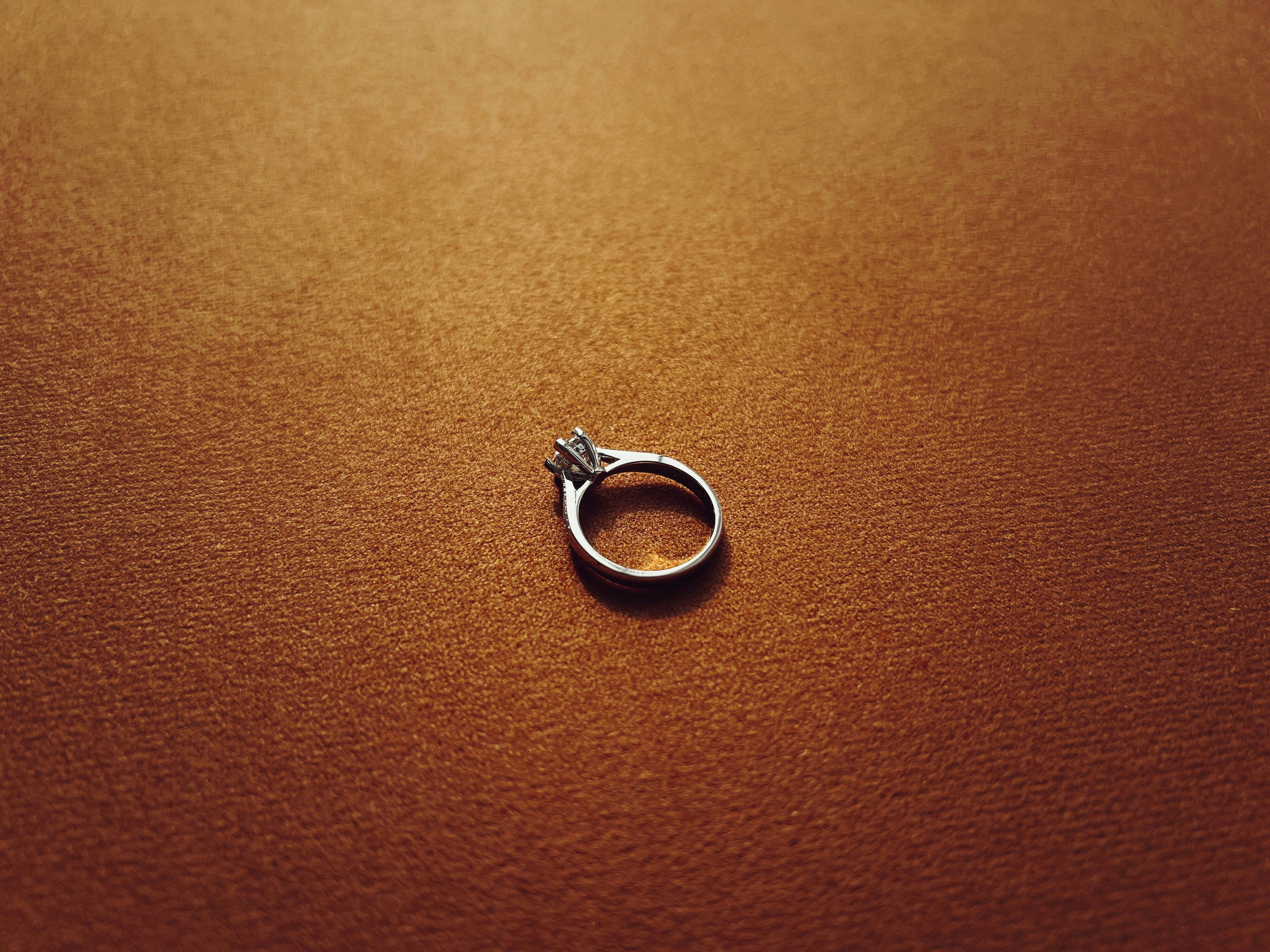 a silver ring sitting on top of a brown surface