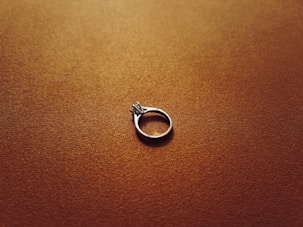 a silver ring sitting on top of a brown surface