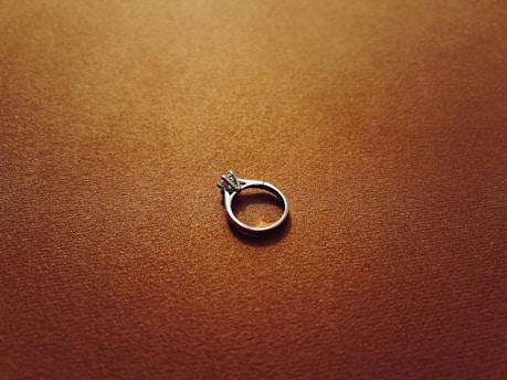a silver ring sitting on top of a brown surface