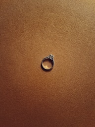 a diamond ring sitting on top of a brown surface