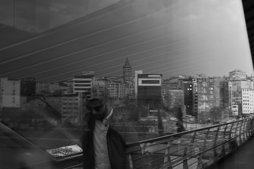 a man walking across a bridge next to tall buildings