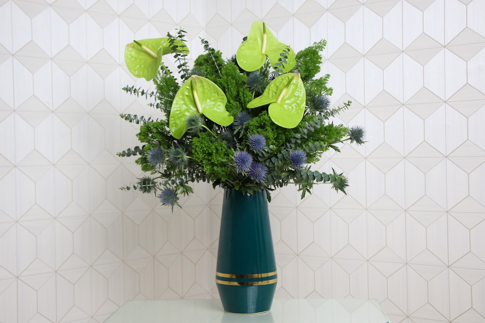 a green vase filled with lots of green flowers