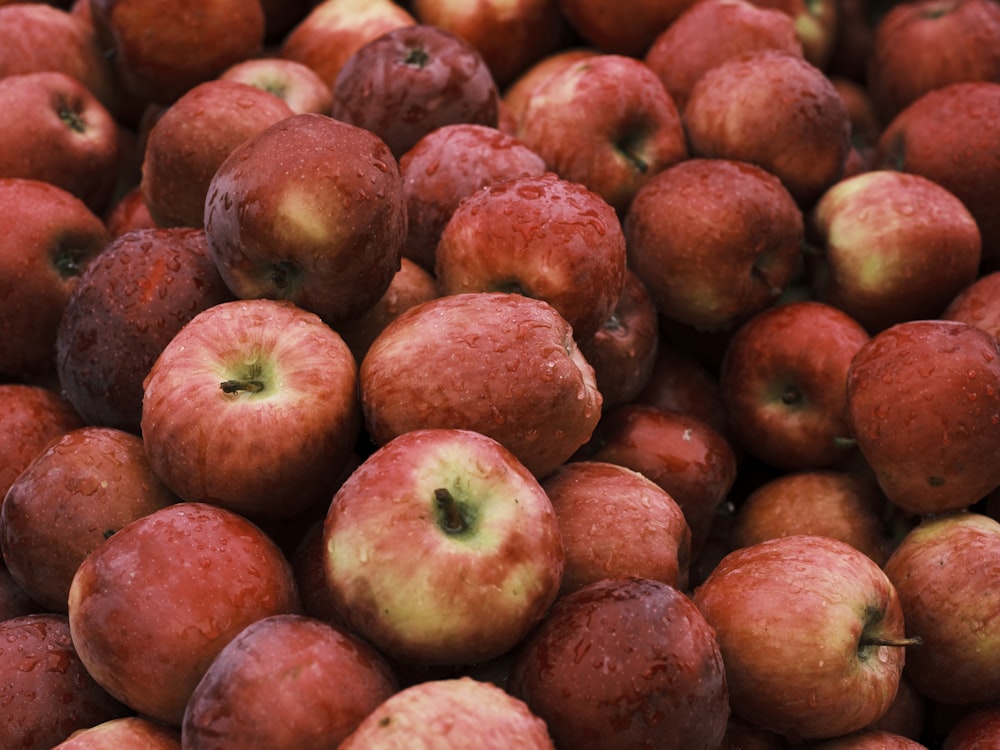 a pile of red apples sitting next to each other