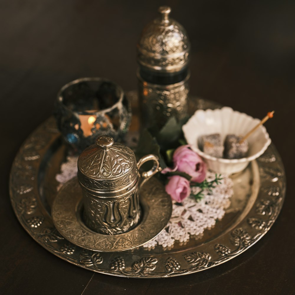 a tray with a silver tea pot and two cups on it