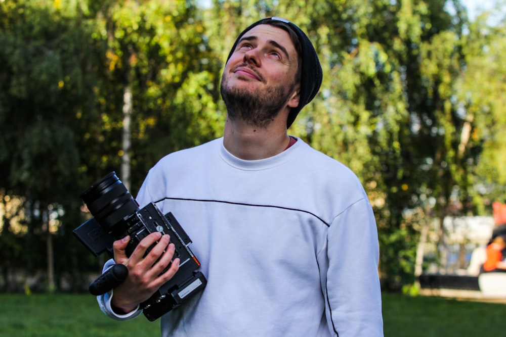 a man holding a camera in a park
