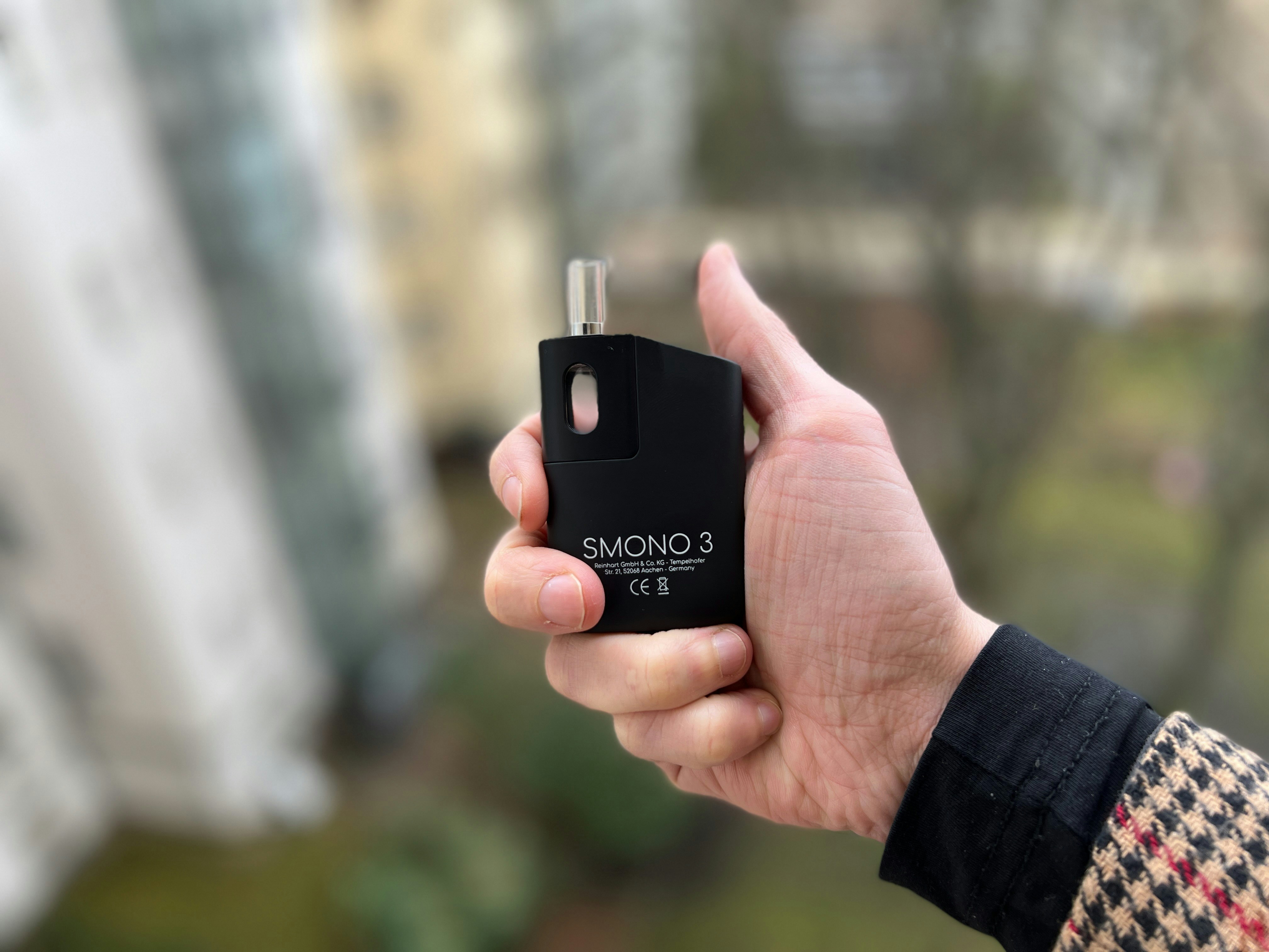 a person holding a black electronic device in their hand