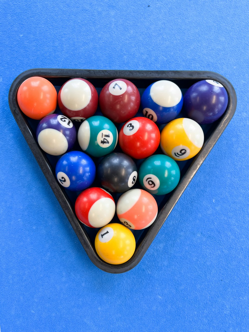 a triangle shaped pool table filled with pool balls
