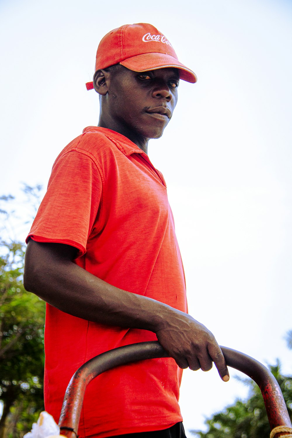a man in an orange shirt and a red hat