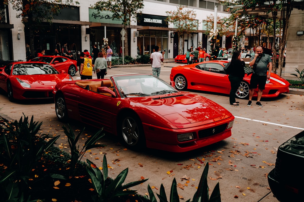 a group of red sports cars parked in a parking lot
