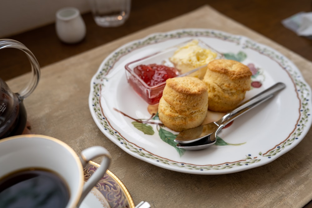 a white plate topped with pastries next to a cup of coffee