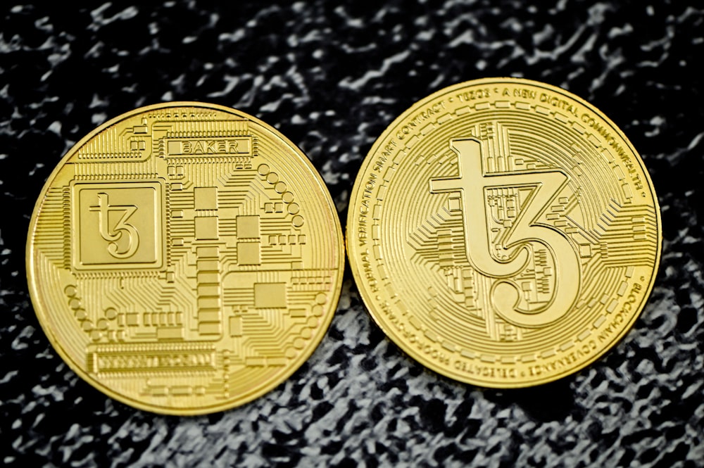 a close up of two gold bitcoins