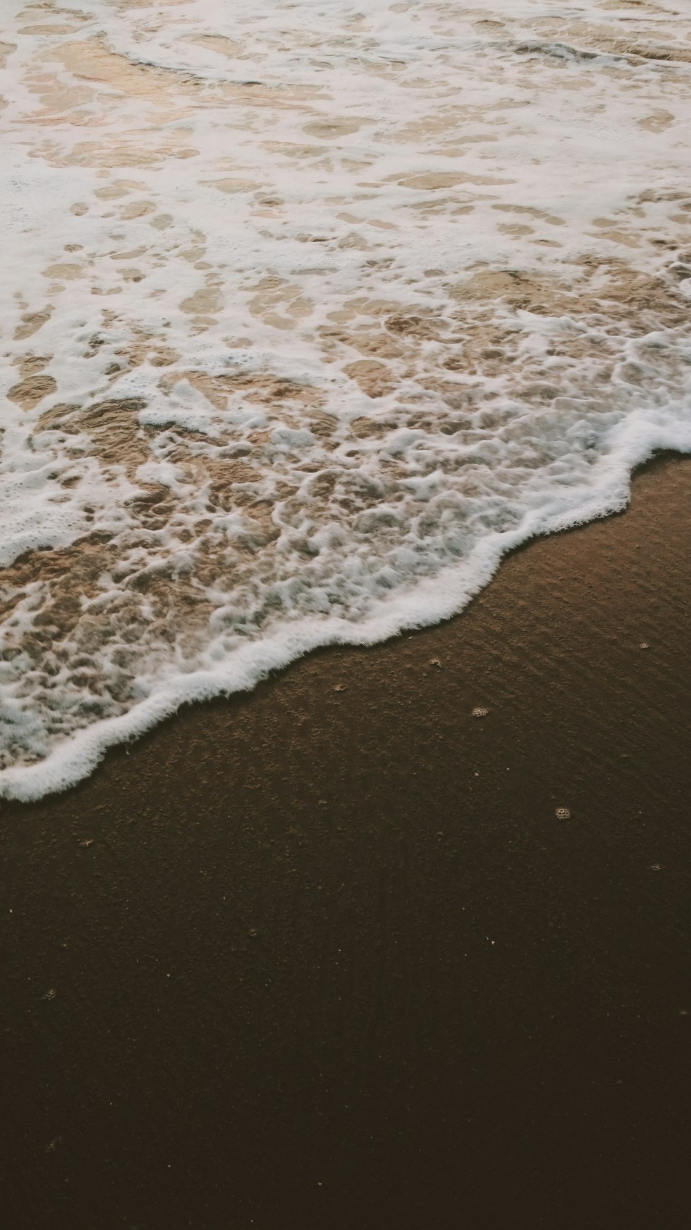 a person walking on the beach with a surfboard