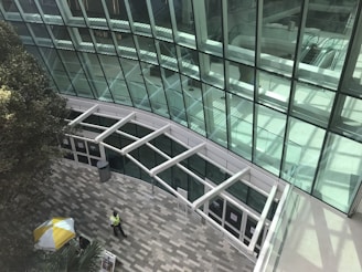 a man walking down a walkway next to a tall building