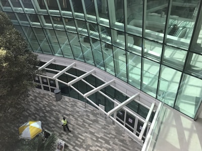 a man walking down a walkway next to a tall building