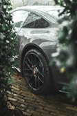 a car parked on a cobblestone road in the rain