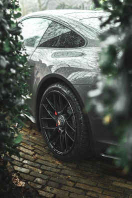 a car parked on a cobblestone road in the rain