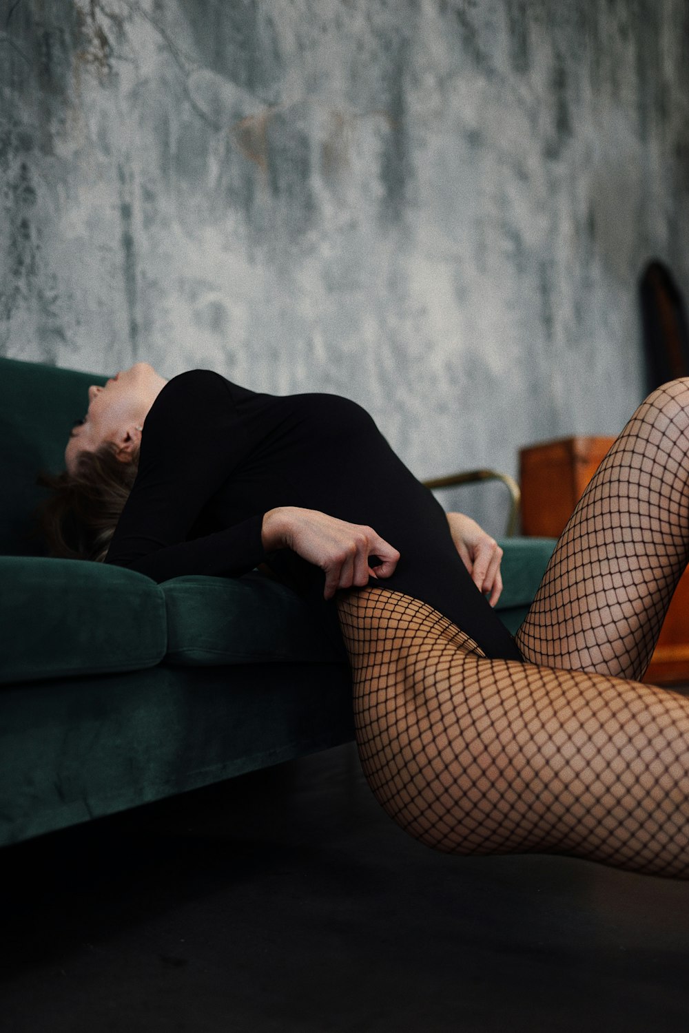 Una mujer con medias de red acostada en un sofá