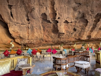 MG TURIZM a restaurant with tables and chairs in front of a cliff