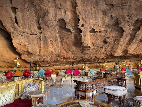 MG TURIZM a restaurant with tables and chairs in front of a cliff