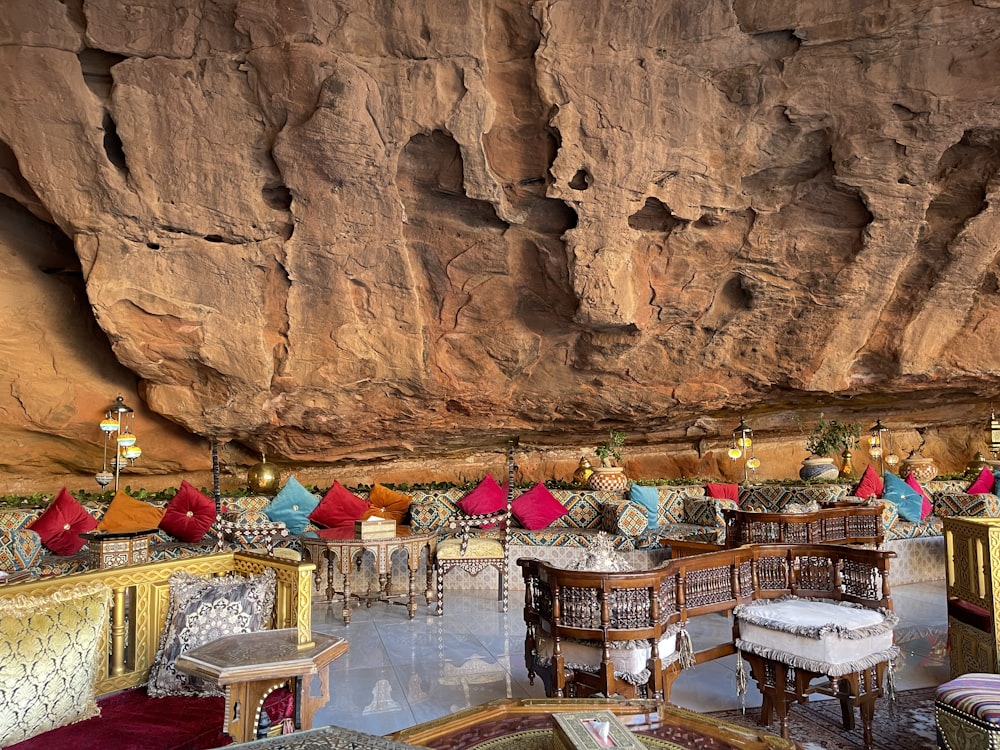 a restaurant with tables and chairs in front of a cliff