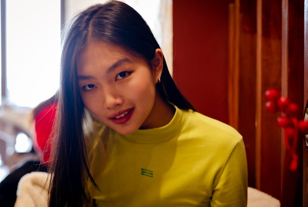 a woman with long hair wearing a yellow shirt