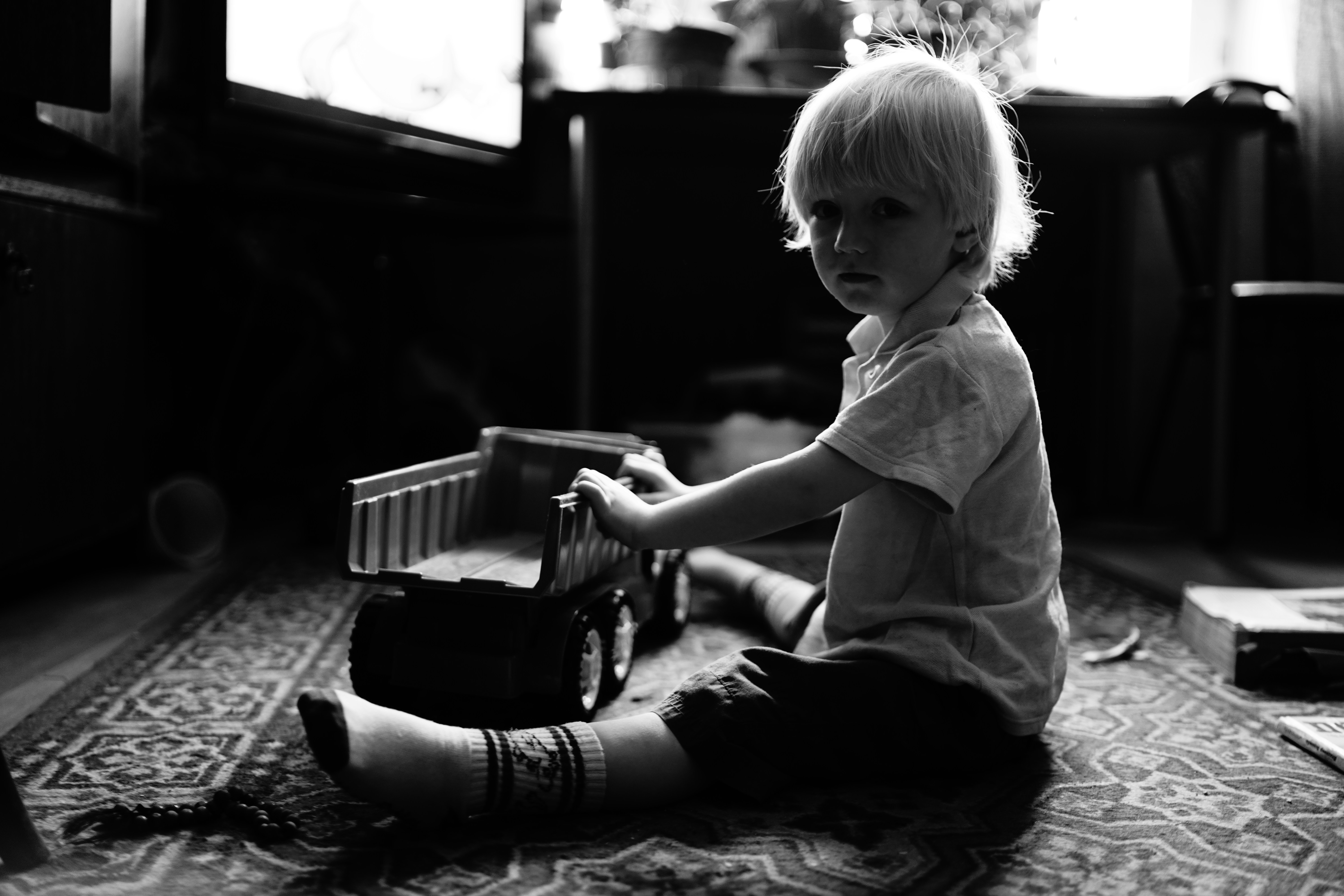 a little girl sitting on the floor playing with a toy