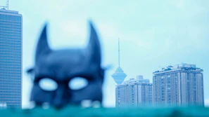 A detailed view of a Spider-Man mask’s eye lens reflecting a city skyline at night.