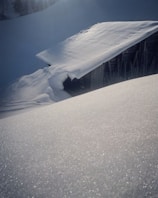 Close-up of a weatherproof prefabricated cottage’s snow-load roof glistening under bright sunlight.