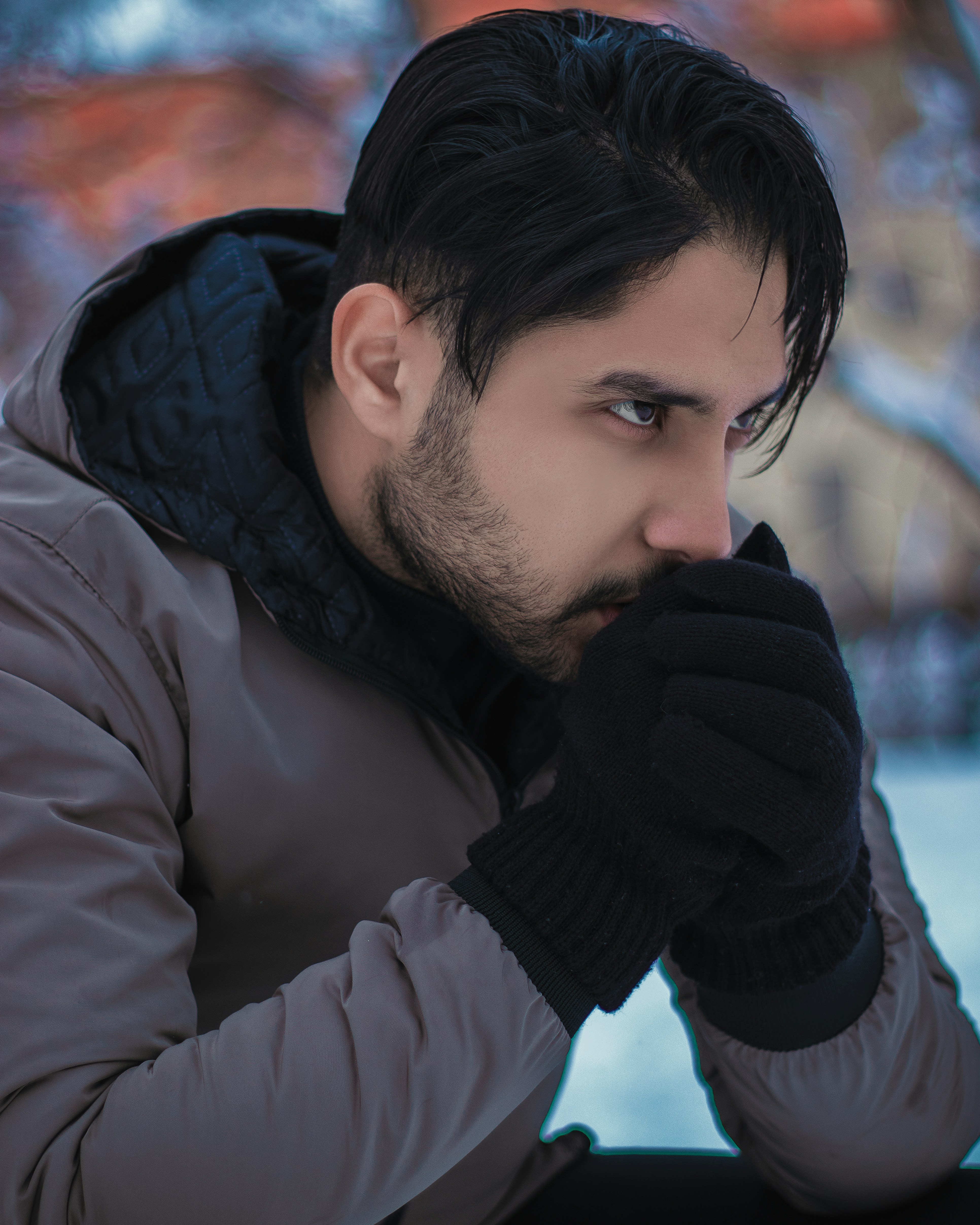 Un homme en veste porte sa main à son visage