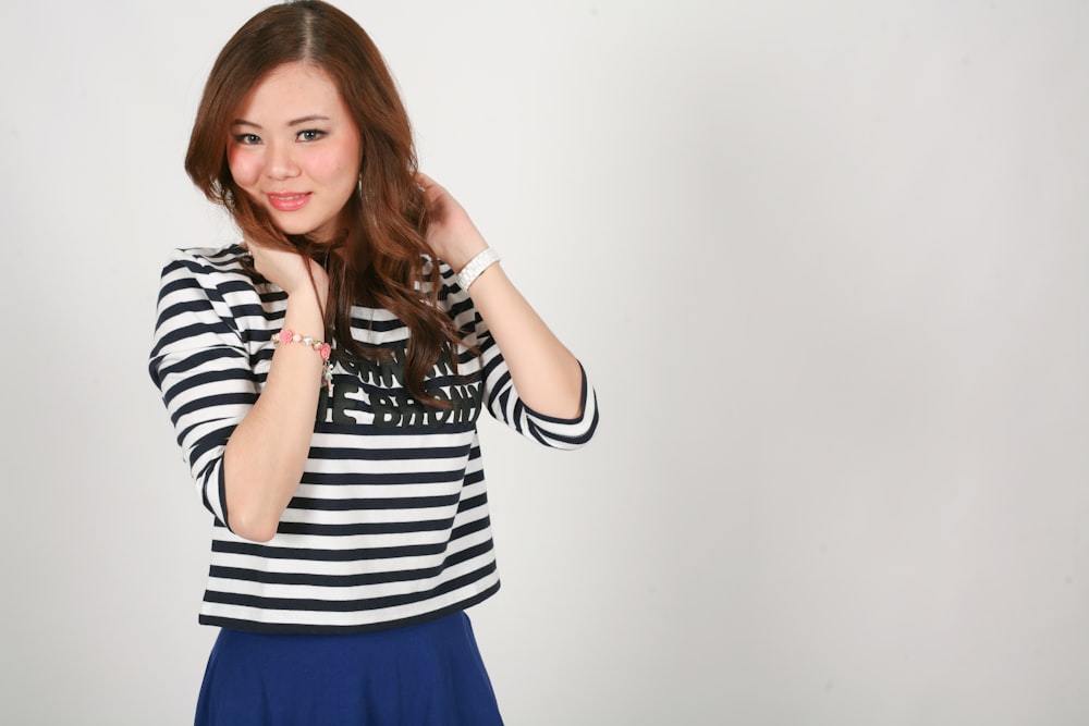 a woman posing for a picture in a striped shirt