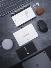 a desk with a keyboard, mouse, mouse pad and other items