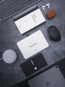 a desk with a keyboard, mouse, mouse pad and other items