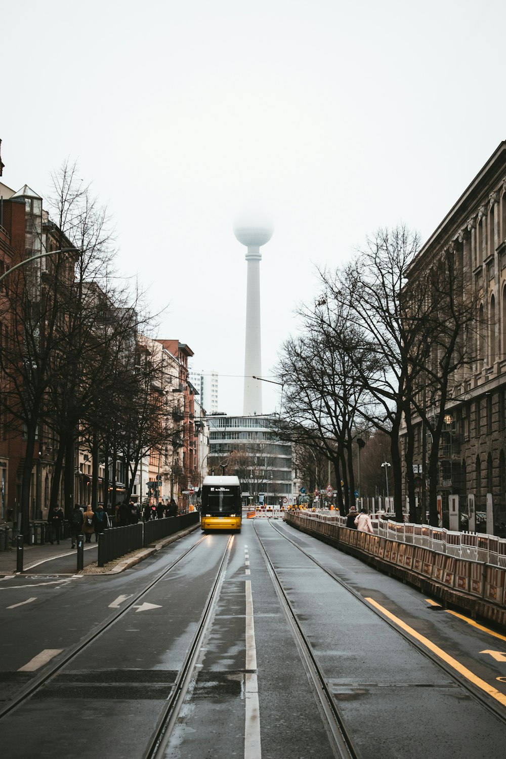 a bus driving down a street next to tall buildings