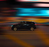 Close-up frame from a Nissan commercial featuring sleek car motion against urban night lights.