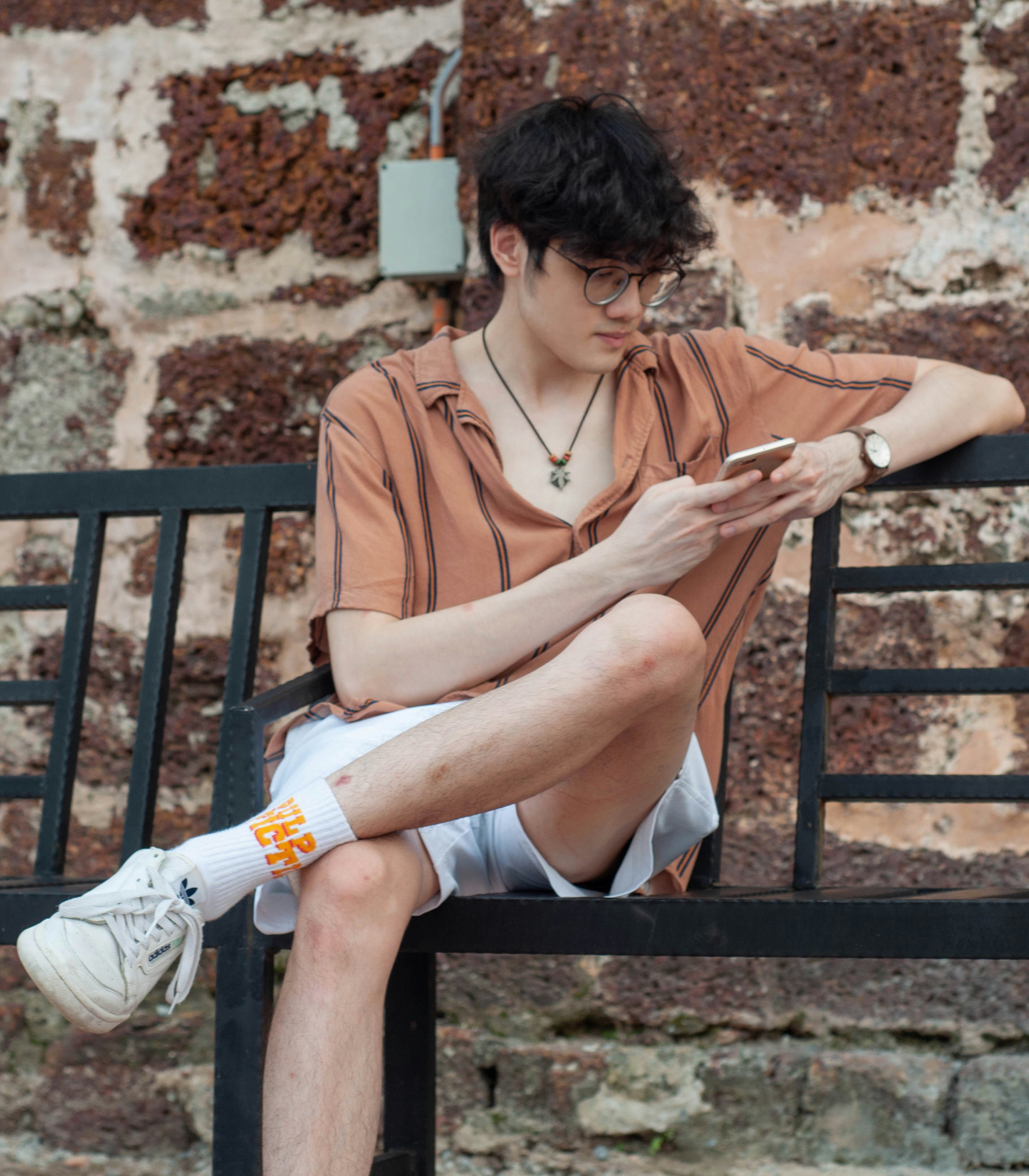 a man sitting on a bench using a cell phone