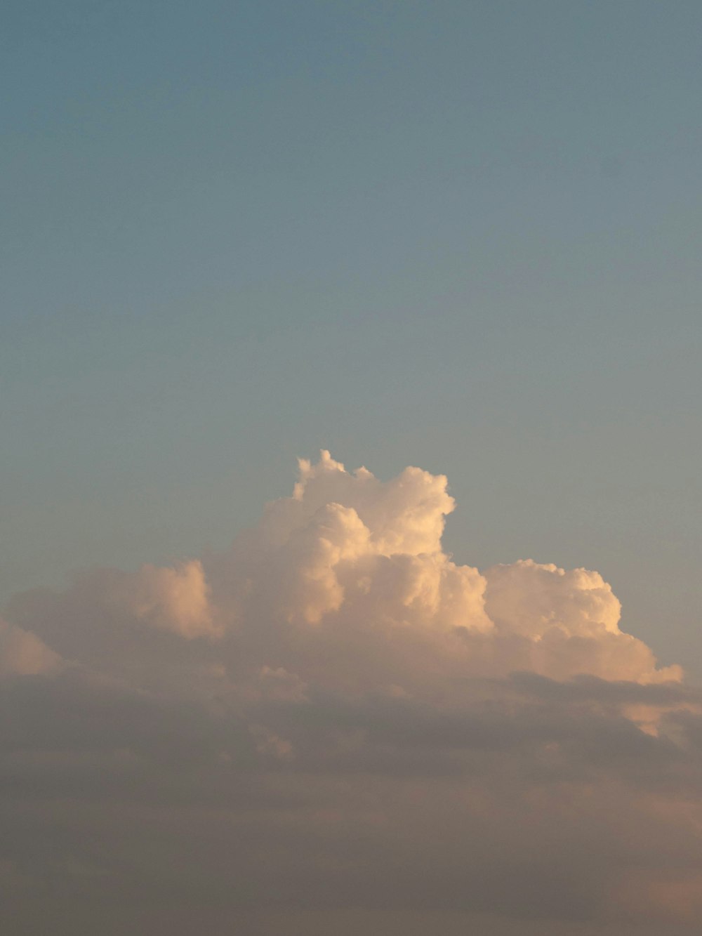 a plane flying in the sky with a cloud in the background