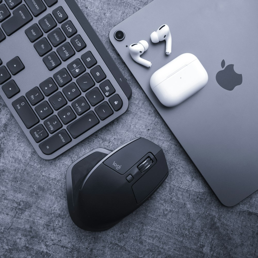 an apple keyboard, mouse, and headphones on a table