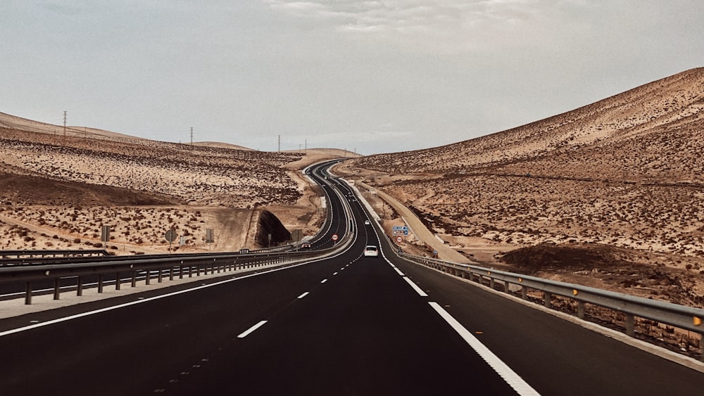 Une autoroute traversant un désert avec une montagne en arrière-plan