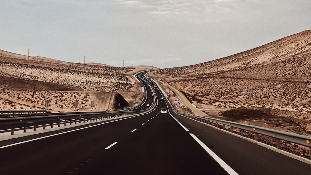 a highway going through a desert with a mountain in the background