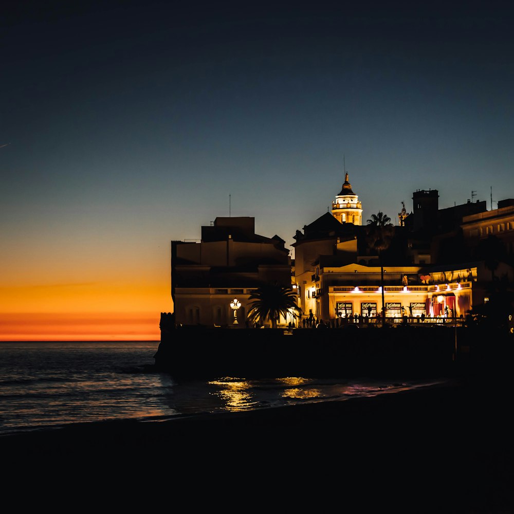 a building on the beach with a clock tower in the background